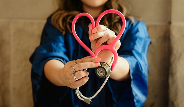 staff member holding stethoscope in shape of heart